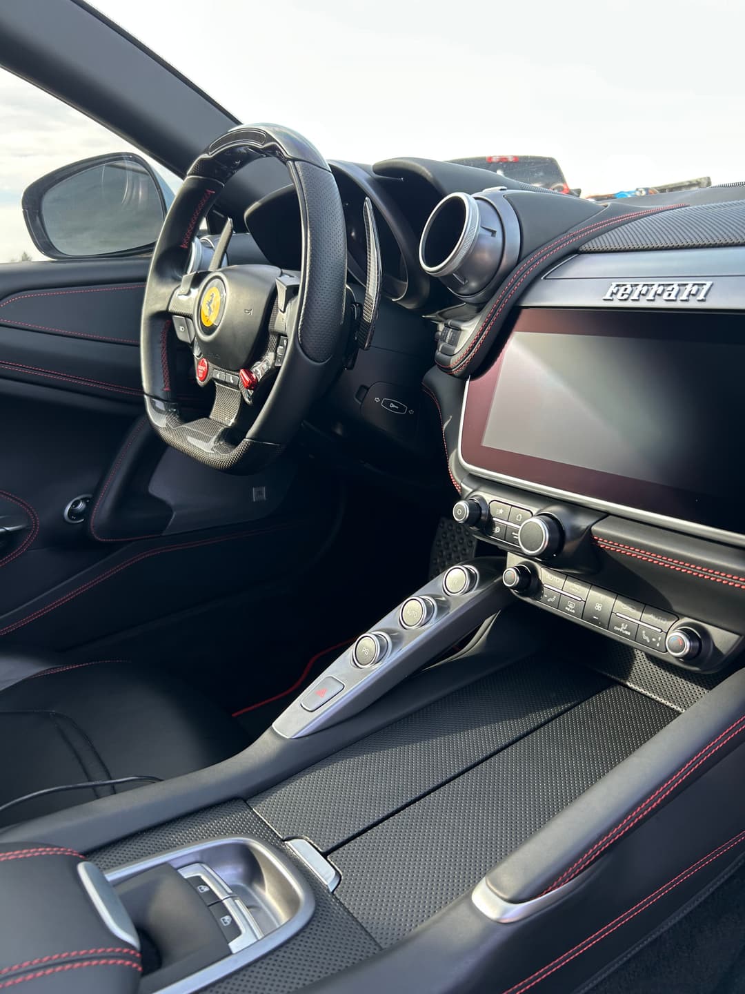 Ferrari interior with sleek dashboard, leather seats, and modern controls.